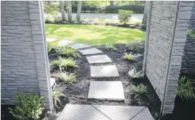  ??  ?? Paving stones, fringed in ferns, run from the lower patio across to the front door.