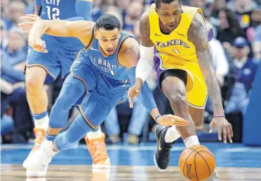  ?? [PHOTO BY BRYAN TERRY, THE OKLAHOMAN] ?? Oklahoma City’s Andre Roberson dives for the ball beside Los Angeles’ Kentavious Caldwell-Pope during Wednesday’s game.