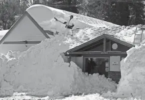  ?? JOSE SANCHEZ/AP ?? A worker clears snow off a roof in Rimforest, Calif., March 8 after a series of storms. California’s wildly wet winter of 2022-23 is in stark contrast to how dry the state has been over the past few YEARS.MARCIO