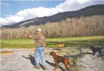  ?? STAFF FILE PHOTO BY DOUG STRICKLAND ?? Steve Persinger points to a wheat field at Rising Fawn Gardens on Feb. 23 in Rising Fawn, Ga. Rising Fawn Gardens offers a yoga studio and corporate retreats in addition to growing wheat and herbs, but the only available internet access is via satellite.