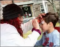  ?? ?? Eva Perez paints a Spiderman mask on 3-year-old James Eckhart.