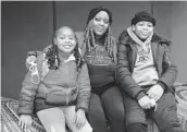  ?? ERIN SCHAFF/THE NEW YORK TIMES ?? Kemika Cosey with her children, Zurie, left, and Zamir, students at Garrison Elementary School in Washington, D.C., on Tuesday.