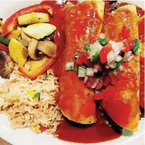  ?? [PHOTO BY DAVE CATHEY, THE OKLAHOMAN] ?? Beef enchiladas in red sauce with Spanish rice and calabacita­s con hongos.