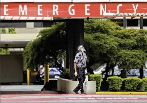  ?? JOHN SPINK /JOHN.SPINK@AJC.COM ?? A security guard waits Wednesday at the emergency entrance at Wellstar Atlanta Medical Center. Statewide, intensive care units were at 96% of capacity Wednesday. However, in five of Georgia’s 14 hospital regions, ICUS were over 100% capacity.