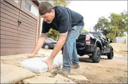  ?? Wally Skalij Los Angeles Times ?? MARK JEFFERSON readies for this week’s storm by laying sandbags outside his home Sunday in Kagel Canyon, an area scorched by last month’s Creek fire.