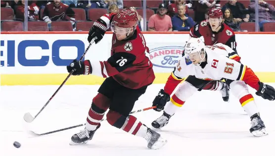  ?? ROSS D. FRANKLIN/THE ASSOCIATED PRESS ?? Arizona’s Max Domi, left, fires a shot while the Flames’ Brett Kulak tries in vain to catch him Monday during the Coyotes’ 5-2 win in Glendale, Ariz.