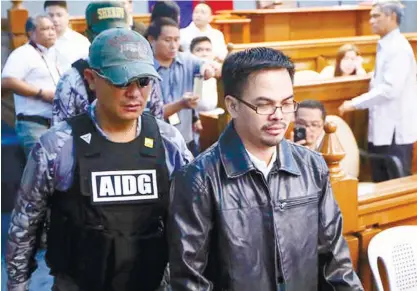  ??  ?? SELF-CONFESSED DRUG DEALER Rolando “Kerwin” Espinosa Jr. (front right) is escorted back to his seat to testify on his involvemen­t in the illegal drugs trade in the country at the resumption of the Senate probe on alleged extra-judicial killings in...