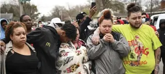  ?? AaRON laviNSky / STaR TRiBuNE ?? MOURNING: Family and friends of Daunte Wright, 20, grieve hours after they say he was shot and killed by police, Sunday in Brooklyn Center, Minn. At top, Damik Wright, brother of Daunte Wright, holds Daunte’s son Daunte Jr. over his head to look at police officers assembling with riot gear Sunday.