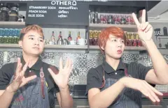  ?? PHOTOS BY APICHART JINAKUL ?? Hearing-impaired baristas serve coffee using sign language.