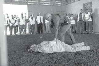  ?? ADRIA MALCOLM/THE NEW YORK TIMES ?? Rick Besecke, right, a Border Patrol supervisor and agent, pins Hugo Garza, an actor, last month during a detention training program at the Federal Law Enforcemen­t Training Center in Artesia. New training in New Mexico for future Border Patrol agents...