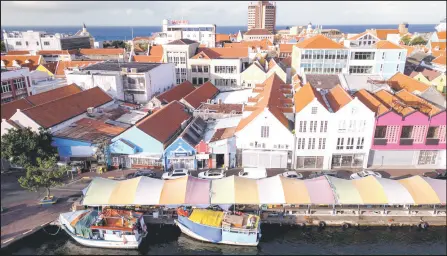  ?? — AFP photos by Federico Parra ?? Aerial view of the Punda floating market and colonial buildings on the waterfront of old town Willemstad, Curacao, in the Dutch Caribbean.