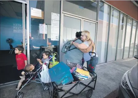  ?? Francine Orr Los Angeles Times ?? THE YOUTH POLICY INSTITUTE closed down on Oct. 25; two people hug outside its facility in Hollywood on its final day. The nonprofit’s bankruptcy filing alleges that former Chief Executive Dixon Slingerlan­d misspent some of the group’s funds on personal expenses.