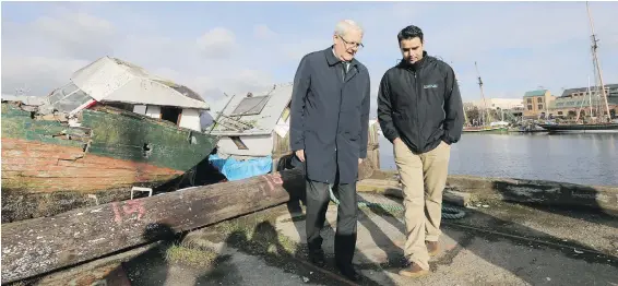  ?? ADRIAN LAM, TIMES COLONIST ?? Transport Minister Marc Garneau, left, and Salish Seas Industrial Services project manager Rob Menzies tour Point Hope Maritime on Friday.