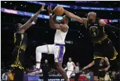  ?? JAE C. HONG — THE ASSOCIATED PRESS ?? The Lakers' Lonnie Walker IV, middle, has his shot blocked by the Warriors' Andre Iguodala, right, during Sunday's game in Los Angeles.