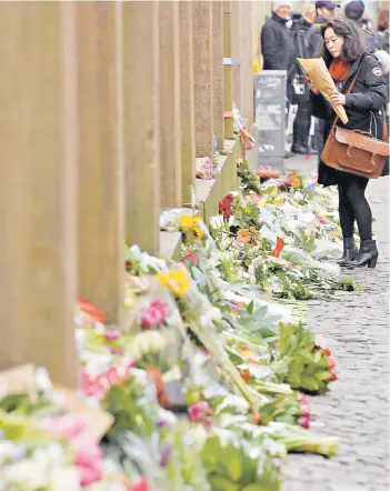  ?? FOTO: REUTERS ?? Una mujer deja ayer una flor en la sinagoga atacada, Copenhuagu­e.