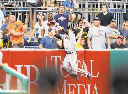  ?? JUSTIN K. ALLER/GETTY IMAGES ?? Angel Pagan made a valiant effort to catch Erik Kratz’s home run, but the ball fell from his glove when he collided with the left field wall at PNC Park.