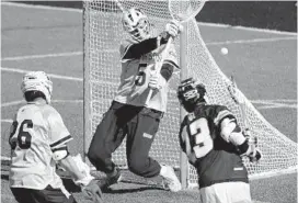  ?? KARL MERTON FERRON/BALTIMORE SUN ?? Towson long-stick midfielder Koby Smith, left, pressures Johns Hopkins attackman Kyle Marr into missing a shot against goalkeeper Tyler Canto on Saturday afternoon.