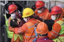  ?? CHEN HAO / XINHUA VIA AP ?? In this photo released by Xinhua News Agency, rescuers carry a miner who was trapped in a mine to an ambulance in Qixia City in east China’s Shandong Province, Sunday.