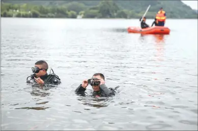  ?? Photo: cnsphoto ?? Divers came to rescue on Tuesday after a bus carrying unspecifie­d number of passengers crashed into a local reservoir in Anshun, Southwest China’s Guizhou Province on Tuesday around noon. As of 10 pm Tuesday, 37 have been found and 21 of them died. Twelve of 37 found have been identified to be students, five of whom died.