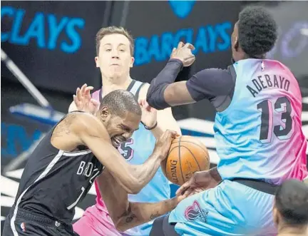  ?? FRANK FRANKLIN II/AP ?? Nets’ Kevin Durant scrambles for the ball between the Heat’s Duncan Robinson and Bam Adebayo on Saturday night.