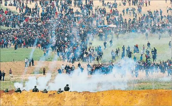  ?? JACK GUEZ / AFP ?? Soldados israelíes disparan con fuego real y lanzan gases contra la multitud que había ocupado la zona de seguridad junto a la frontera en Gaza