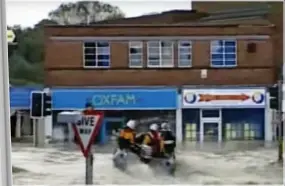  ??  ?? Ladybird said the eye-catching cover of the Prince’s book, left, was inspired by a video of emergency services in Uckfield high street during the floods in East Sussex in 2000, above. But the people stranded on the roof have been added in.