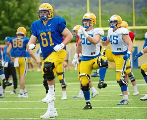  ?? Pam Panchak/Post-Gazette ?? Ryan Jacobi, left, and the rest of Pitt’s football team loosen up before practice Thursday on the South Side.