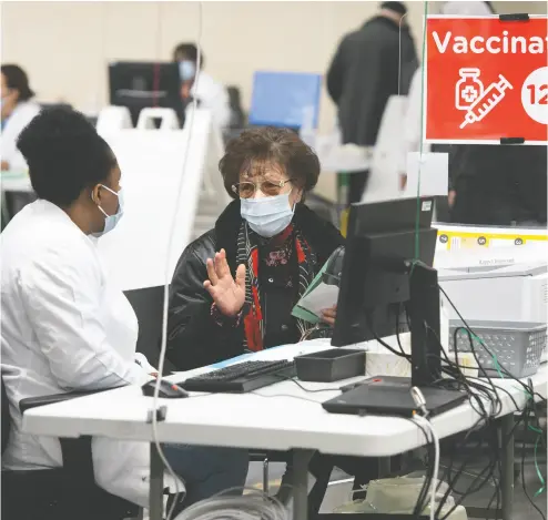  ?? GRAHAM HUGHES / THE CANADIAN PRESS FILES ?? A woman waits to receive a booster vaccine dose at Olympic Stadium in Montreal. For those aged 70-79, the mortality
rate for the fully vaccinated is 62 per million, compared to 28 per million among those who have been boosted.