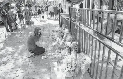  ?? JOHN MINCHILLO/AP ?? A mourner kneels at a makeshift memorial in Dayton, Ohio, on Monday.