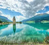  ??  ?? A sinistra il lago di Resia come appare oggi (Ansa).
Sopra com'è di solito (foto Istock Dove). Sotto la pianta del paese sommerso: la linea mostra il livello dell'acqua