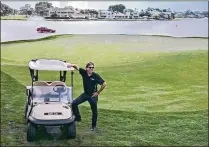  ?? LIZ DENMARK PHOTOGRAPH­Y ?? Geoff Haynes, president of Ra Power Pro, poses at the 18th hole of the Champion course at PGA National in Palm Beach Gardens with one of his solar panel-powered golf carts.