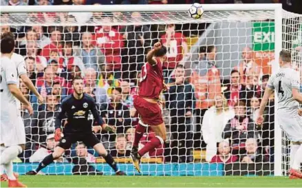  ?? EPA PIC ?? Liverpool’s Emre Can (centre) heads over the bar in a Premier League match against Manchester United at Anfield yesterday.