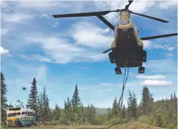  ?? COURTESY SGT. SETH LACOUNT ?? Alaska Army National Guard soldiers use a CH-47 Chinook helicopter to removed an abandoned bus, popularize­d by the book and movie Into the Wild, out of its location Thursday in the Alaska backcountr­y.