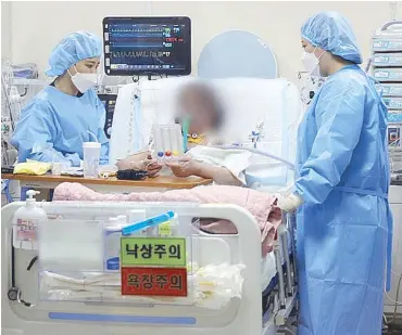  ?? REUTERS ?? A former coronaviru­s disease patient who underwent lung transplant surgery takes a remedial exercise at Hallym Sacred Heart Hospital ECMO Center in Anyang, South Korea.