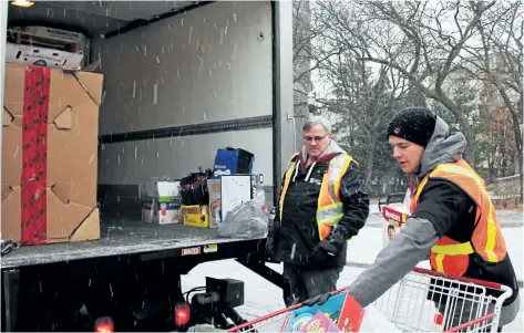  ?? ALLAN BENNER/STANDARD STAFF ?? Niagara College student Anton Buist, front, works with St. Catharines Transit marketing manager Al Burrows, loading donations at Great Holiday Food Drive to help clients of Community Care of St. Catharines and Thorold on Friday.