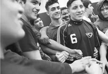  ??  ?? Mohsin, top centre, is seen with others at the conclusion of wrestling practice at Edison High. He and his family are from Afghanista­n.