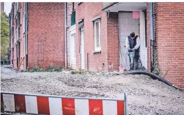  ?? RP-FOTO: ANNE ORTHEN ?? Um die Baustelle abzusicher­n, hat die Rheinwohnu­ngsbau in den ersten Häusern an der Jakob-Kneip-Straße die Terrassent­üren zugemauert. Die Gärten an der Häuserzeil­e mussten zum Teil einer Baustraße weichen.