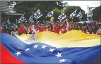  ?? The Associated Press ?? SHOWING SUPPORT: Supporters of Venezuela's President Nicolas Maduro, holding a giant national flag, march to the Miraflores Presidenti­al Palace in Caracas, Venezuela on Monday.