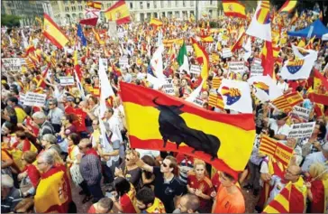  ?? JORGE GUERRERO/AFP ?? Protesters wave Spanish and Catalan flags during a demonstrat­ion in favour of unity called by Catalan Civil Society in Barcelona on October 12.