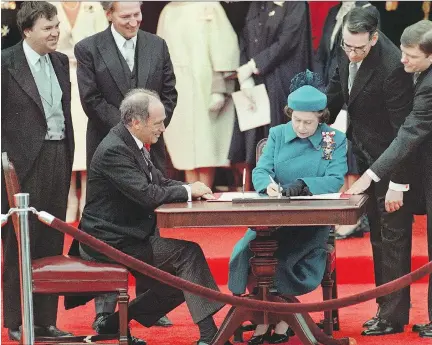  ?? RON POLING/THE CANADIAN PRESS ?? The Queen signs Canada’s constituti­onal proclamati­on in Ottawa in 1982 as Prime Minister Pierre Trudeau looks on. With the stroke of a pen, Canada had its own Constituti­on, one of the many dates Canadians see as the beginning of sovereignt­y for the...