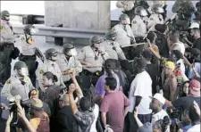  ?? Gregory Bull/Associated Press ?? Police form a line in front of protesters Wednesday in El Cajon, Calif., as dozens demonstrat­ed over the killing of a black man who was shot by an officer.