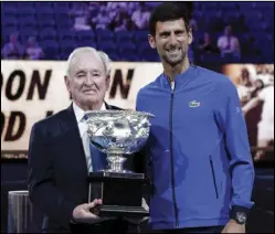  ?? (AP file photo) ?? In this 2019 photo, Novak Djokovic (right) presents a trophy to Rod Laver during the 50th anniversar­y celebratio­n for the Australian Open and Laver’s second Grand Slam at the Australian Open in Melbourne, Australia. If Djokovic wins the U.S. Open to complete the first calendar-year Grand Slam in men’s tennis in 52 years, Laver will be there to welcome him into a remarkably exclusive club.