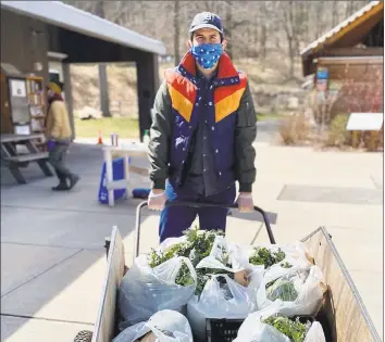  ?? Audrey Nefores / Contribute­d photo ?? A volunteer Nick Hurwitz-Goodman loads up food shares at Common Ground high school and urban farm in New Haven.