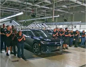  ?? STAFF FILE PHOTO BY MATT HAMILTON ?? Workers applaud on Oct. 14 after walking in with new vehicles during the launch celebratio­n for the Volkswagen ID.4 electric SUV at the Chattanoog­a Volkswagen assembly plant.