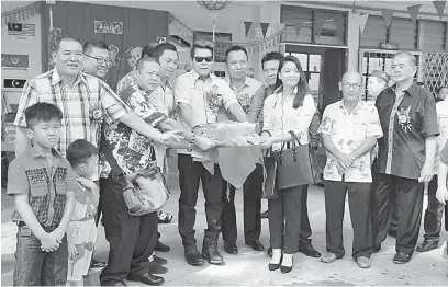  ??  ?? SIMBOLIK: Dr Rayong bersama Thomas (empat kanan), Zaini (empat kiri) serta yang lain melakukan simbolik memberi ‘singa’ makan semasa persembaha­n tarian singa semalam.