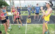  ?? NWA Democrat-Gazette/ANDY SHUPE ?? April Steiner Bennett (right), a former University of Arkansas and Olympic pole vaulter, works with campers Friday at Ramay Junior High School in Fayettevil­le.