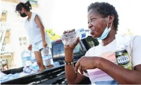  ?? Photograph: Mario Tama/Getty Images ?? A woman drinks water distribute­d by volunteers with Water Drop LA on Sunday in Los Angeles.