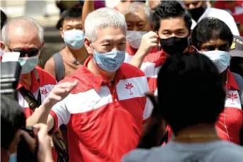  ?? — AFP photo ?? Lee Hsien Yang (centre), the brother of Hsien Loong and a member of the opposition Progress Singapore Party, greets people during a walkabout ahead of the general election in Singapore.