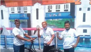  ?? EKO HENDRI/JAWA POS ?? MENGHIAS KAMPUNG: Dari kiri, Aseyan, Imam Safii, dan Anang menunjukka­n karya mereka di Jalan Tembok Gede.