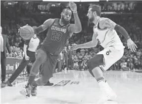  ??  ?? Cavaliers forward LeBron James moves past 76ers guard Marco Belinelli on Friday in Philadelph­ia. BILL STREICHER/USA TODAY SPORTS